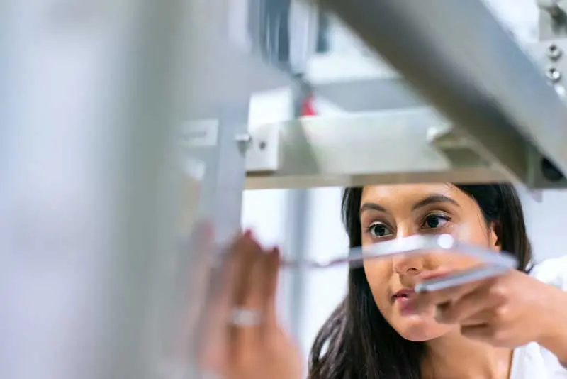 A young PCI employee working with manufacturing equipment
